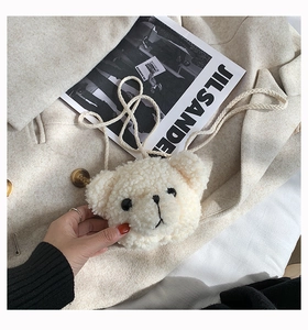 Close-up of cute plush cream-colored bear-shaped crossbody bag made of soft sherpa wool