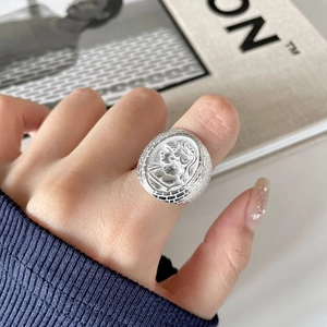 Minimalist 925 sterling silver coin ring with vintage portrait relief worn by a model