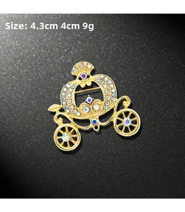 Detail of golden pumpkin carriage brooch featuring colorful rhinestones and size specs