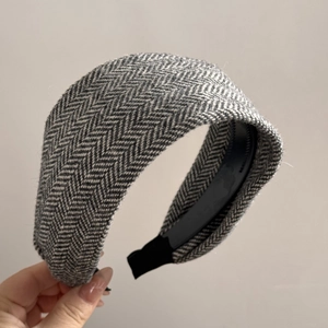 Detailed view of grey herringbone knit pattern on wide vintage style headband