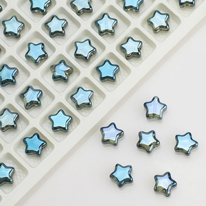 Detailed view of 8mm blue crystal star beads with iridescent finish on a white tray