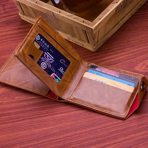 Men's brown bifold leather wallet with card slots and snap button on vintage wood