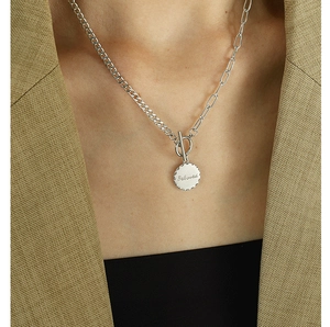 Detail view of silver OT buckle necklace with 'Beloved' engraved round pendant worn on model