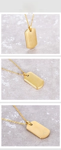 Close-up of matte gold shield pendant necklace showing S.STEEL material engraving
