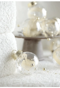 Close-up of elegant transparent Christmas ball with champagne ribbon and golden beads detail