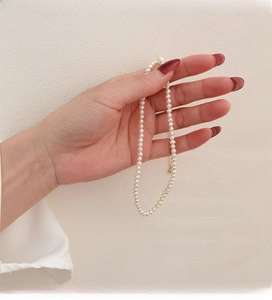 Detail of 4-5mm natural freshwater pearl necklace with adjustable gold clasp