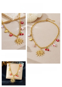 Vue détaillée du collier en acier doré avec pendentifs émaillés soleil, cerise et coquillage