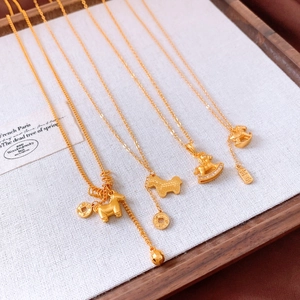 Detailed view of four gold-plated horse pendants with elegant coins on white display board