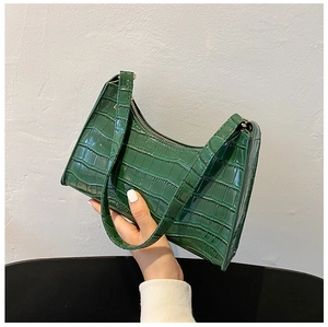 Detailed view of the dark green crocodile pattern leather and top zipper of the underarm bag