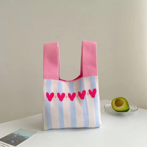 Minimalist knit tote bag with pink heart pattern and striped design on white surface