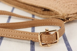 Macro view of adjustable tan leather strap with golden buckle and woven texture detail