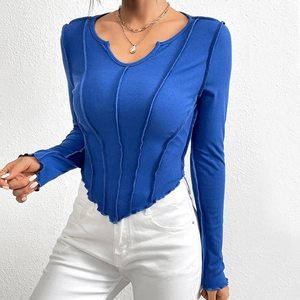 Close-up of bright blue ribbed knit top with exposed seams and irregular wavy hemline