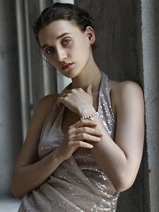 Detail of 18K gold plated shell charm and pearl bracelet on female model wrist