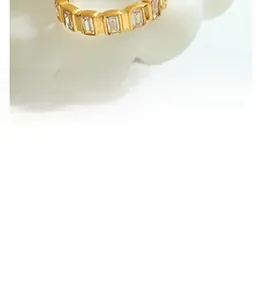 Detailed view of gold baguette cut crystal ring on a decorative white display tray