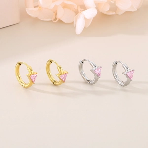 Detail of 18K gold and silver hoop earrings featuring triangular pink zircon stones