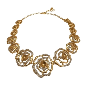Elegant gold flower necklace with hollow petals and sparkling crystals on white background