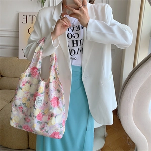 Borsa tote in tela a fiori abbinata a un blazer bianco per un look estivo fresco