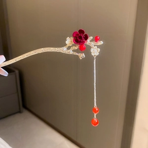 Détail d'un pic à cheveux vintage avec fleurs en velours et longs glands dorés