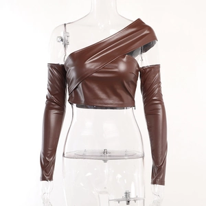 Dettaglio del crop top monospalla in pelle PU marrone con texture e manica lunga