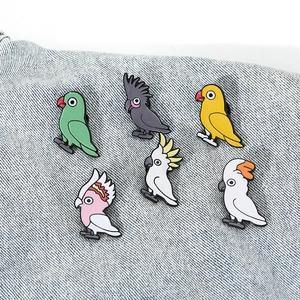 Détail de six épingles en émail de perroquets colorés avec des motifs de dessins animés