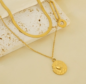 Detail of double-layer gold heart pendant necklace showing snake chain and embossed charm