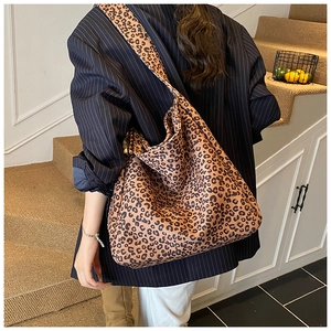 Fashionable leopard print canvas tote bag with wide strap shown on model's shoulder