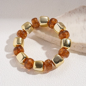 Detailed macro view of retro acrylic amber beads and golden metallic cube spacers