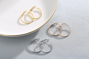 Detailed close-up of textured hoop earrings in gold, silver, and rose gold finishes