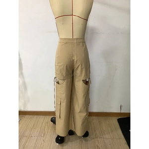 Detail of khaki cargo pants featuring waist cut-out design and large side pockets