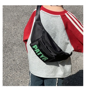 Close-up of a black nylon kids chest bag with green PATYR letter print and metal zipper