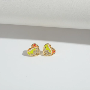 Macro shot of gold heart studs with colorful enamel inlay and sparkling crystals