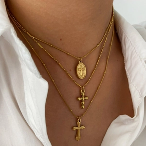 Three-layer gold titanium steel necklace featuring vintage cross and oval saint pendants