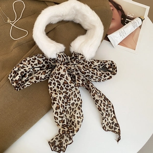 Close-up of white faux fur collar with leopard print scarf tied in a bow over brown coat