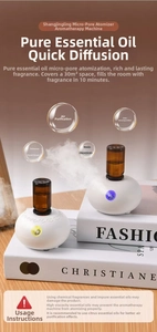 Detailed view of white essential oil diffuser with micro-porous atomization on fashion books