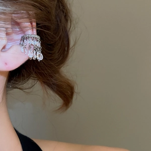 Vue détaillée de manchette d'oreille argentée avec zircons et pendentifs goutte d'eau