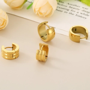 Close-up of 18K gold plated titanium steel hoop earrings with smooth and triple-layered textures