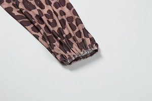 Detailed view of elastic cuffs and classic leopard print pattern on a long sleeve dress