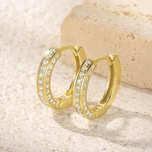 Macro shot of S925 sterling silver stamp on golden geometric hoop earrings