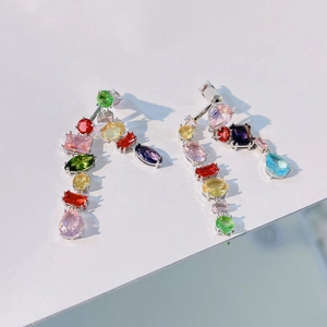 Detailed close-up of rainbow crystal drop earrings with vibrant multi-shaped gemstones