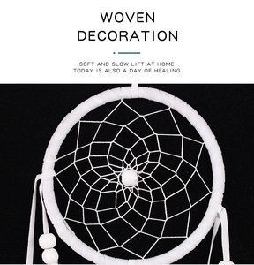 Close-up of a handmade white woven dreamcatcher with symmetrical mesh and central bead