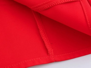 Close-up of red fabric hem stitching and high-quality overlock seam construction