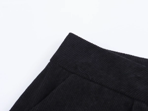 Dettaglio ravvicinato di pantaloncini neri in velluto a coste con vita e trama