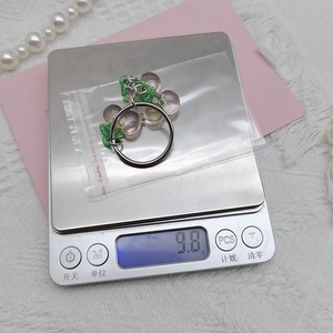 Detailed view of translucent grape-shaped resin keychain on scale showing 9.8g weight