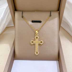 Detail of a luxurious hollow cross pendant with sparkling zircon in gold finish