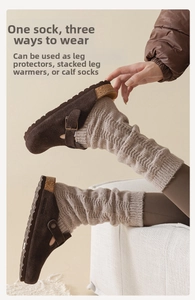 Détail de jambières en grosse maille avoine avec d'élégantes mules en daim marron tendance