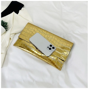 Detailed view of golden crocodile textured envelope clutch bag with phone size reference