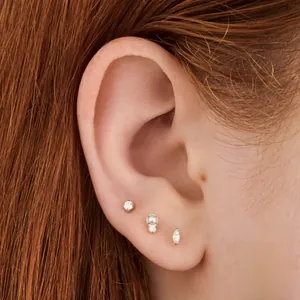 Macro shot of S925 sterling silver stud earring set with zircons and pearls on ear