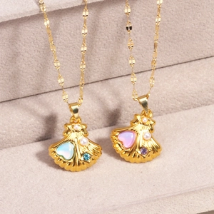 Gold shell pendant necklaces with heart gemstones and pearls on beige fabric display