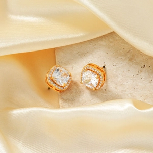Detailed view of square halo zircon stud earrings with gold plating on stone display