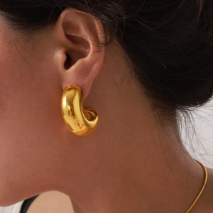 Polished 18K gold-plated C-shape thick hoop earring on female model minimalist style